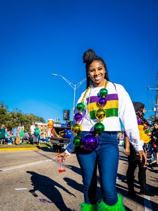 A young woman dresses in the purple, green and gold of Mardi Gras at the Krewe of Dionysus parade in Slidell.