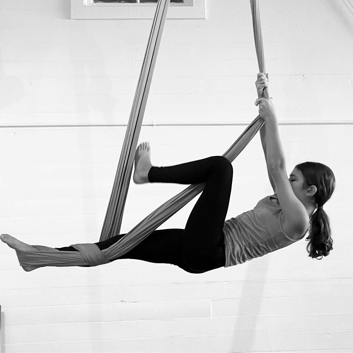 A young woman practices yoga on aerial silks in Covington.